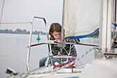 Girl on a sailing boat reading, Brandenburg an der Havel, Brandenburg, Germany