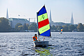 Girl in sailing dinghy Optimist on outer Alster, Hamburg, Germany