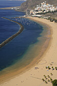 Sandy beach, palm trees and boats at Playa de las Teresitas, view from viewpoint towards  San Andres, Tenerife, Canary Islands, Spain