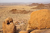 Red rock tower standing over savannah with small camp site, Moweni camp site, Damara land, Namibia