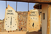Stone board with opening hours of National Park, Sossusvlei, Namib Naukluft National Park, Namib desert, Namib, Namibia