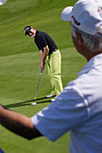 Two men playing golf, Prien am Chiemsee, Bavaria, Germany