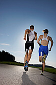 Two runners on road near Munsing, Upper Bavaria, Germany