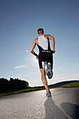 Male runner on road near Munsing, Upper Bavaria, Germany