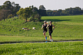 Two female runners on path near Munsing, Upper Bavaria, Germany