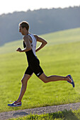 Male runner on path near Munsing, Upper Bavaria, Germany