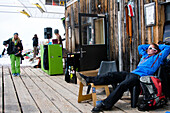 Young people on terrace of Cafe No Name, Flims Laax Falera ski area, Laax, Grisons, Switzerland