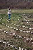 Prairieville, Michigan - A woman walks a labyrinth at Circle Pines camp The labyrinth is an aid to meditation the spiritualism © Jim West