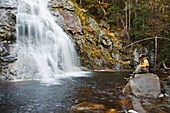 Nancy Brook Scenic Area - A hiker enjoys the view of Nancy Cascade located along the Nancy Pond Trail in the White Mountains, New Hampshire USA