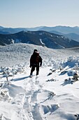 Snowshoer on the summit of South Twin Mountain during the winter months in the White Mountains, New Hampshire USA