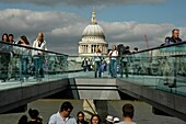 People walking on and below Millennium Bridge with St Paul’s Cathedral in the distance, London, England