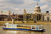 Passanger ferry under Millenium Bridge River Thames central London England UK Europe