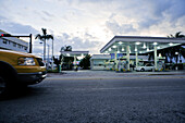 Taxi in front of gas station, petrol station in the evening light with dramatic sky, Miami, Florida, USA