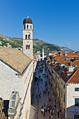 Pedestrians in the old Town Placa with Franciscan church monastery tower seen from the city wall, Dubrovnik, Croatia, Europe