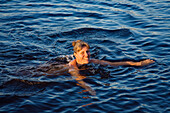 Ältere Frau schwimmt im Boasjön See, Smaland, Schweden