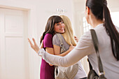 Young woman welcoming friends at home