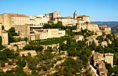 Gordes with the Château de Gordes and the Saint-Firmin church on the Monts de Vaucluse hill, Provence, France