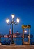 Gondola moorings at night before dawn beside Grand Canal at San Marco in Venice Italy