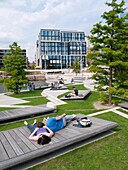 People relaxing at modern Vasco Da Gamma Platz in new Hafencity property development in Hamburg Germany