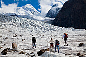 Hikers passing Grenz Glacier, Castor and Pollux in background, Zermatt, Canton of Valais, Switzerland, myclimate audio trail