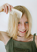Girl (12 years) combing hair