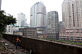 Strassenszene, Wohnhäuser und Hochäuser, Frau läuft entlang Weg voll mit Müll, Chongqing, VR China