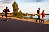 Skateboarder and walkers near Cospuden Lake, Leipzig, Saxony, Germany