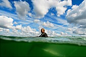 An unidentified surfer sits in his surfboard while he waits for a wave on a warm-up session during the Quiksilver Pro France, which is a part of the Foster's ASP World Tour of Surfing, at Hossegor in the south west coast of France