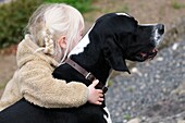 4 year old child hugging her pet dog