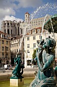 fountain on the square Praca de Dom Pedro IV or Rossio and the ruin of the church Igreja do Carmo in Lisbon, Portugal, Europe