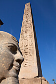 Obelisk und Kolossalstatue Ramses II im Eingagnsbereich des Tempel von Luxor, Luxor, Ägypten, Afrika