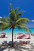 Palm trees and people on the beach in the sunlight, Pereybere, Mauritius, Africa