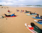 Surflehrer mit Schülern, Escuela cantabria de surf, Playa de Somo, bei Santander, Kantabrien, Spanien