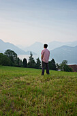 Mann looking over Lake Lucerne in the morning, Weggis, Canton of Lucerne, Switzerland