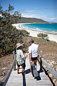 Geoff Mercer, Hotelier und Bewohner von Great Keppel Island, mit Tourist auf dem Weg zum Strand,  Great Keppel island, Great Barrier Reef Marine Park, UNESCO Weltnaturerbe, Queensland, Australien