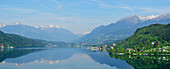 Panorama of lake Millstaetter See with snow covered mountains in the background, lake Millstaetter See, Carinthia, Austria, Europe