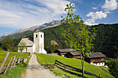 Weg führt auf romanische Kirche St. Nikolaus zu, Bauernhöfe im Hintergrund, Matrei, Osttirol, Österreich, Europa