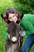 Girl 11 years, with donkey foal, Bavaria, Germany