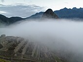 Early morning mist over the ancient Inca ruins at Machu Picchu near Cusco in Peru
