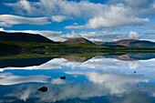 Scotland, Scottish Highlands, Cairngorms National Park Clouds, forest and mountains reflected upon the still waters of Loch Morlich