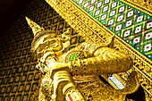 Thailand, Bangkok, The Grand Palace Statue in the ornate setting of the golden grand palace