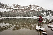 Hiker enjoying the view of Sawtooth montains with the reflection in Phyllis lake, Idaho
