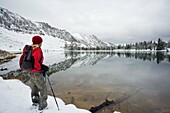 Hiker enjoying the view of Sawtooth montains with the reflection in Phyllis lake, Idaho