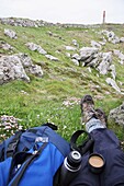 A hiker having a well earned rest drinking a cup of coffee from his flask