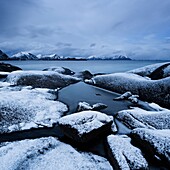 Snow covered rocky coastline at Stamsund, Vestvågøy, Lofoten islands, Norway