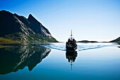 Tourist ferry travel through fjord to Vindstad, Lofoten islands, Norway
