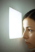 Woman peeking out small window, close-up