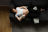 Pregnant woman napping on sofa