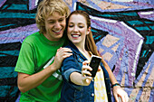 Young couple photographing themselves with cell phone