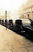 Row of cars parked along road, b&w, toned